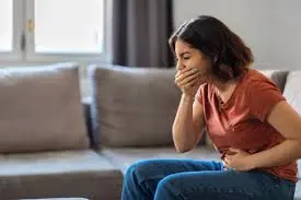 Mulher sentindo enjoo e desconforto gástrico durante o tratamento